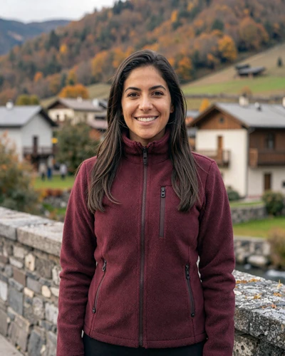Nuria, 31, from Encamp standing near a historic stone bridge in an Andorran mountain village