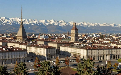 Turin cityscape with Mole Antonelliana tower and baroque architecture with snow-capped Alps in background