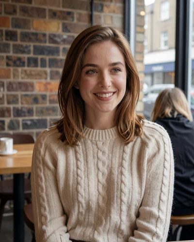 Charlotte, 29, British woman in a cream sweater smiling at a cozy London café