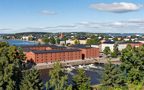 Tampere Finland cityscape with red brick buildings along river rapids between two lakes on summer day