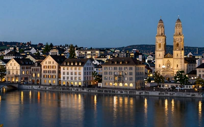 Zurich city skyline at twilight with Limmat river and historic Grossmunster towers