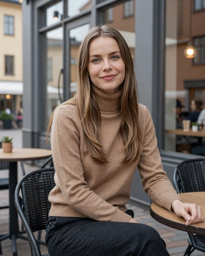 Elsa, 27, a light-haired Swedish woman sitting at an outdoor café in Malmö with a playful smile