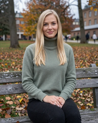 Astrid, 28, Swedish woman in a sage green sweater sitting in a Stockholm park in autumn