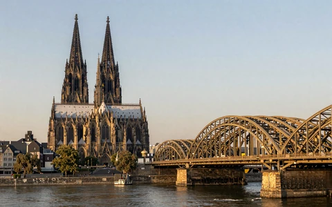 Cologne Cathedral and Hohenzollern Bridge over the Rhine River at golden hour
