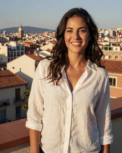 Carmen, 31, Spanish woman from Barcelona with dark wavy hair on a sunlit rooftop terrace