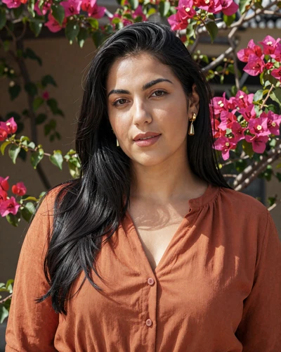 Gabriella, 28, a Maltese woman from Mdina standing in a sunny bougainvillea garden