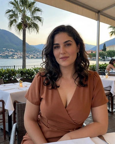 Serena, 33, Swiss-Italian woman from Lugano seated at lakeside terrace in elegant dress