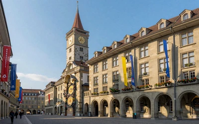 Bern old town medieval arcades and Zytglogge clock tower under clear blue sky